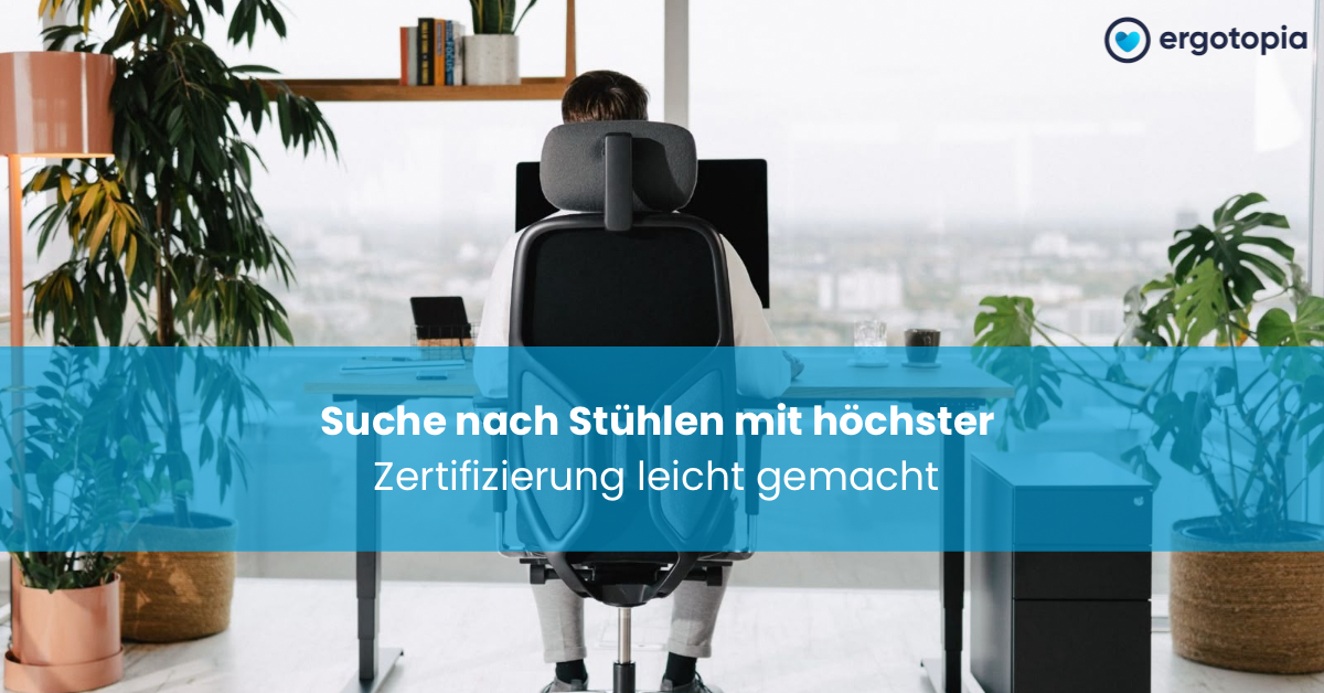Mann sitzt von hinten im schwarzen Bürostuhl mit Kopfstütze zwischen Grünpflanzen am Schreibtisch.